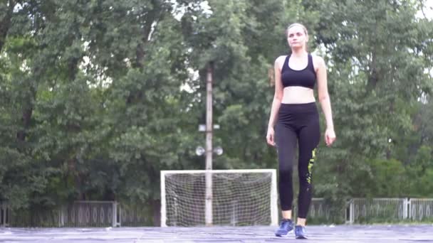 运动服装的年轻运动员妇女在公园的运动场上从事健身运动. — 图库视频影像