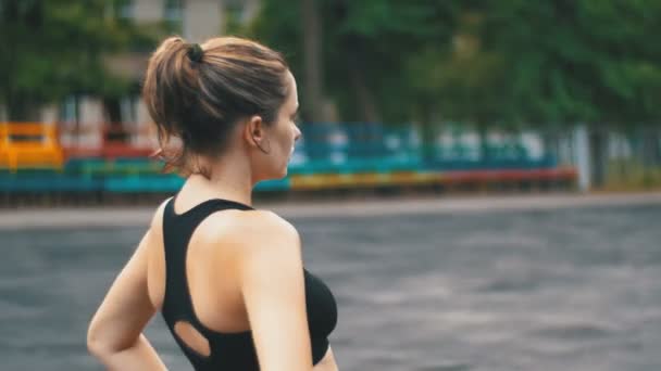 Ung idrottare kvinna i Sport Outfit bedriver Fitness på idrottsplanen i parken. — Stockvideo
