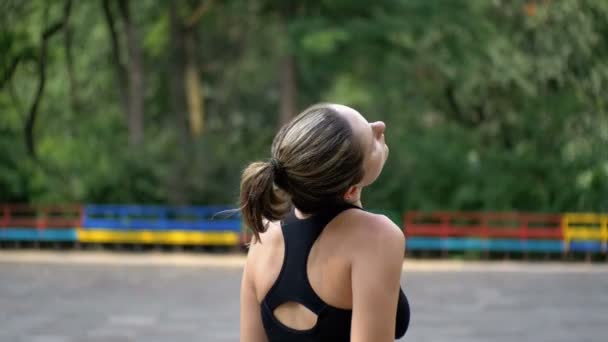 Giovane donna atletica in abito sportivo che fa collo sul campo sportivo nel parco — Video Stock