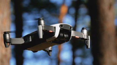 İle robot bir kamera havada uçuşu. Ormandaki yerden quadcopter uçar
