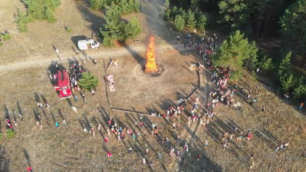 Bir çam ormanı içinde büyük bir kamp ateşi yakın kişi organize toplama havadan görünümü — Stok video