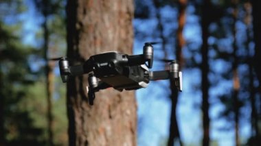 İle robot bir kamera havada uçuşu. Ormandaki yerden quadcopter uçar