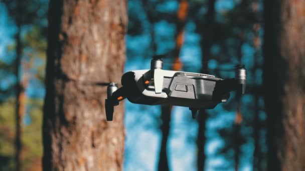 Drönare med en kamera svävar i luften. Quadcopter flyger ovanför marken i skogen — Stockvideo