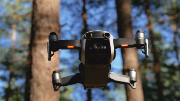 Дрон з камерою висів у повітрі. Квадрокоптер летить над землею в лісі — стокове відео