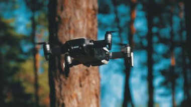 İle robot bir kamera havada uçuşu. Ormandaki yerden quadcopter uçar
