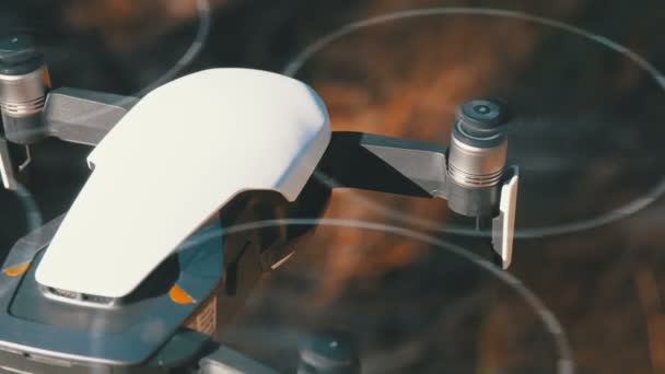 Um drone com uma câmara a pairar no ar. Quadcopter voa acima do solo na floresta — Vídeo de Stock