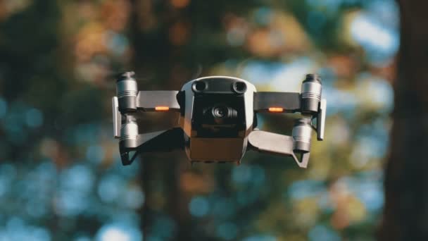 Drönare med en kamera svävar i luften. Quadcopter flyger ovanför marken i skogen — Stockvideo