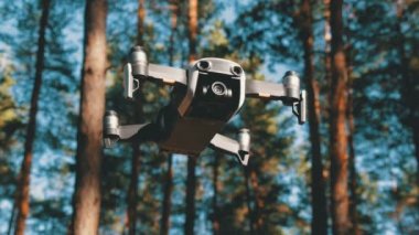İle robot bir kamera havada uçuşu. Ormandaki yerden quadcopter uçar