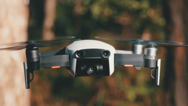 Drone met een camera zweeft in de lucht. Quadcopter vliegt boven de grond in het bos — Stockvideo