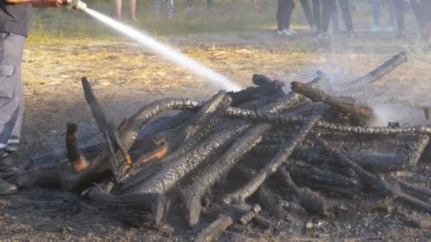 Löschen Sie einen Brand mit Wasser mit einem Feuerwehrschlauch — Stockvideo