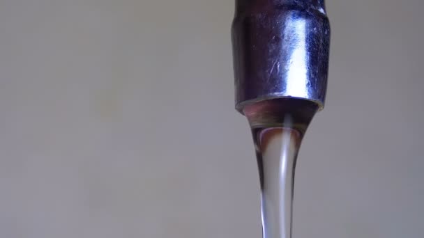 De l'eau qui coule du robinet dans un évier. Mouvement lent 