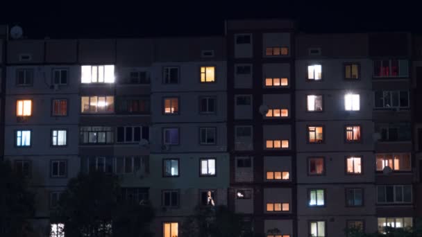 Edificio de varios pisos con iluminación cambiante de ventanas por la noche. Tiempo de caducidad — Vídeos de Stock