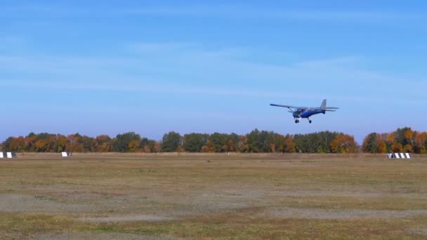 Kleine privé-vliegtuig met een propeller landt op de baan met een grond-coating — Stockvideo