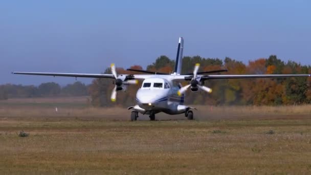 Pequeño avión de doble motor se mueve a lo largo de la pista con una cubierta de tierra — Vídeos de Stock