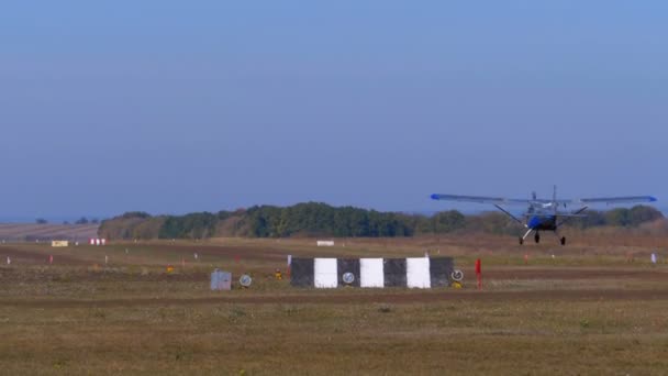 Kleine privé-vliegtuig met een propeller landt op de baan met een grond-coating — Stockvideo