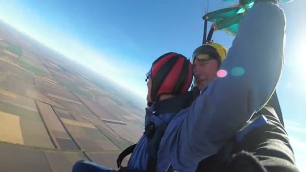 Skydivers voando em tandem sob o paraquedas aberto — Vídeo de Stock