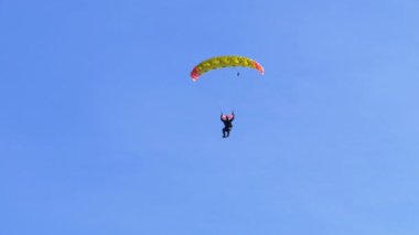 Paraşütçü paraşüt mavi gökyüzüne karşı uçar