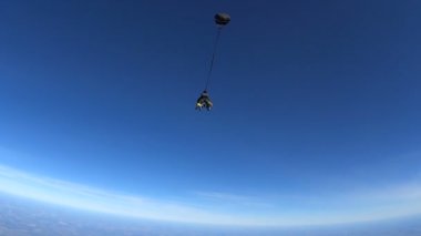 Bir uçak dışında tandem atlama paraşütçü. Ağır çekim