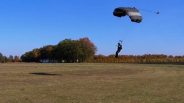 Bir paraşüt ile uçan ve yere indi skydiver. Ağır çekim
