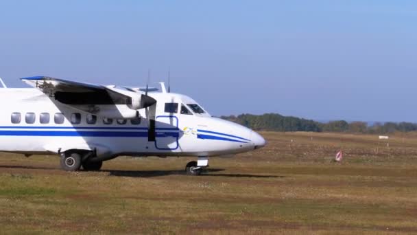 Zweimotoriges Kleinflugzeug bewegt sich mit Bodenabdeckung über die Landebahn — Stockvideo