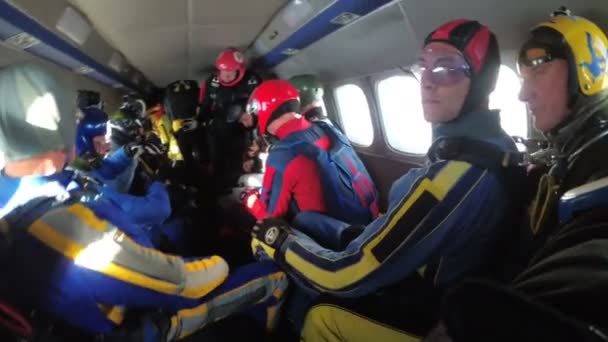 Group of parachutists sits inside a small plane awaiting a jump. Slow Motion — Stock Video