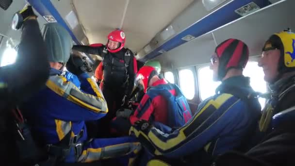 Group of skydivers sits inside a small plane awaiting a jump — Stock Video