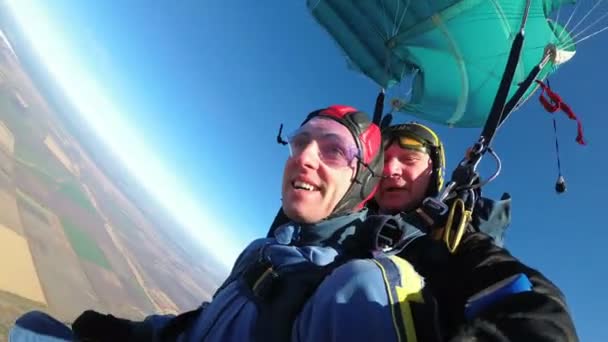 Skydivers voando em tandem sob o paraquedas aberto — Vídeo de Stock