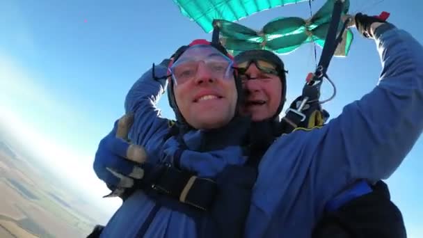 Paracaidistas volando en tándem bajo el paracaídas abierto — Vídeos de Stock