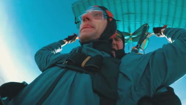 Skydivers flying in tandem under the open parachute — Stock Video