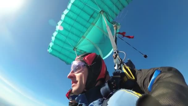 Parachutisten vliegen samen onder de open parachute. Slow Motion — Stockvideo