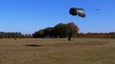 Bir paraşüt ile uçan ve yere indi paraşütçü. Ağır çekim