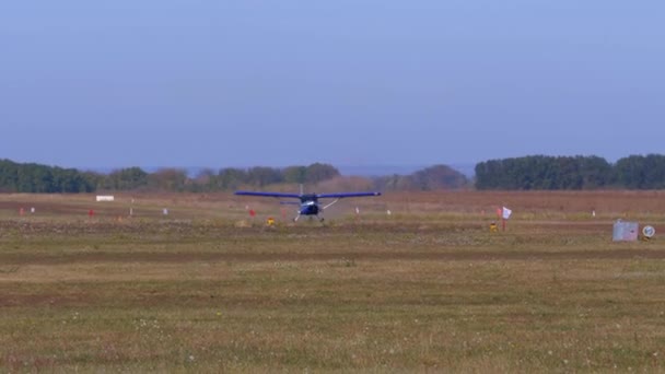 Piccolo aeroplano con elica rotante si muove lungo una pista con un rivestimento a terra — Video Stock