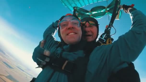 Skydivers voando em tandem sob o paraquedas aberto — Vídeo de Stock