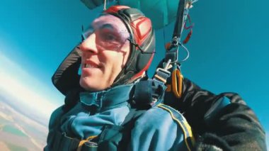 Tandem açık paraşüt altında uçan paraşütçü. Ağır çekim