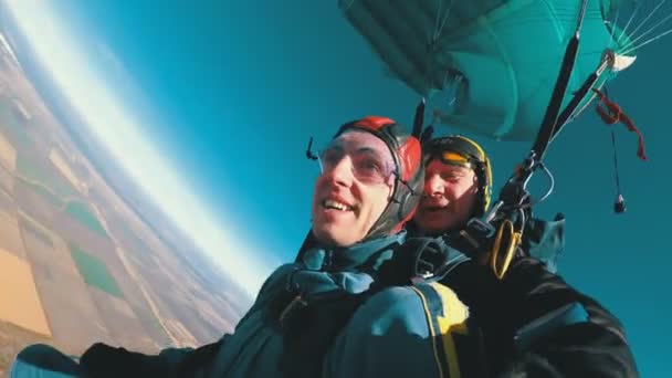 Skydivers flying in tandem under the open parachute — Stock Video