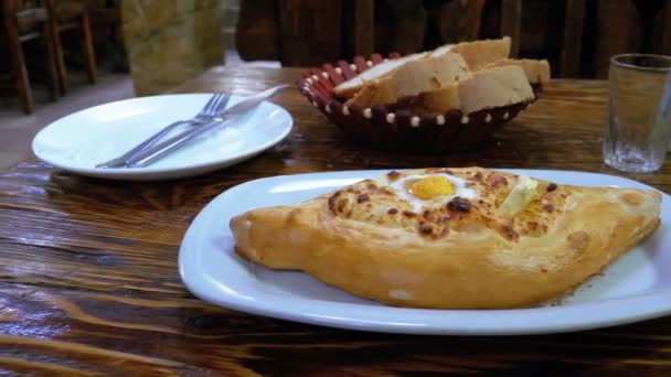 Аджария Хачапури с яйцом на тарелке в ресторане — стоковое видео