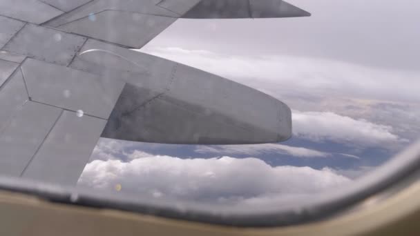 Uitzicht uit het raam van de vliegtuig passagier op de vleugel vliegen boven de wolken — Stockvideo