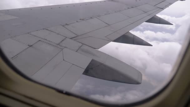 Uitzicht uit het raam van de vliegtuig passagier op de vleugel vliegen boven de wolken — Stockvideo