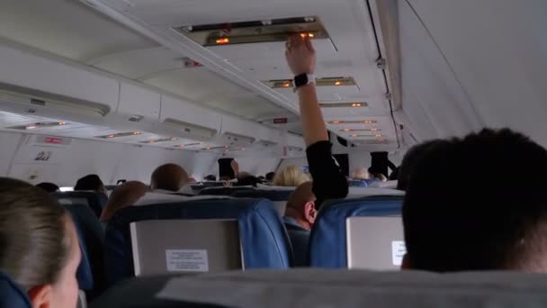 Пассажирская кабина самолета с людьми в креслах во время полета — стоковое видео