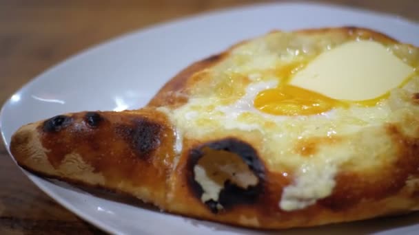 Аджария Хачапури с яйцом на тарелке в ресторане — стоковое видео