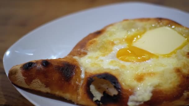 Adjarian Khachapuri med ägg på en tallrik i restaurangen — Stockvideo