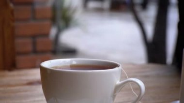 Beyaz fincan çay bir Cafe Cadde penceresinin arka plan üzerinde tablo