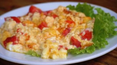 Domates, peynir ve bir restoranda ahşap bir masa üzerinde otlar ile Gürcü omlet tabak.