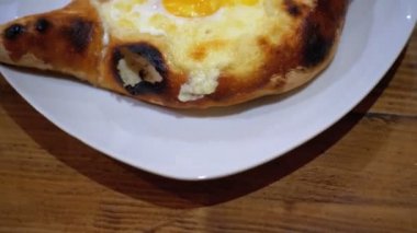 Acara Khachapuri restoranda bir tabakta yumurta ile