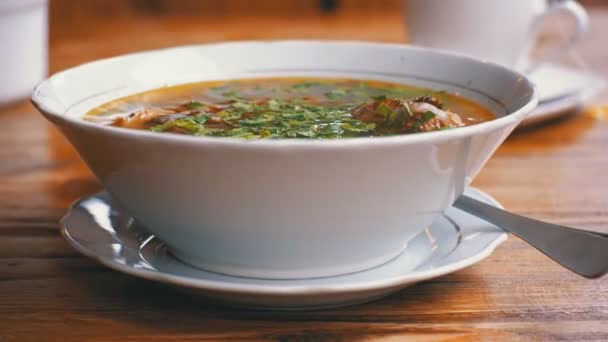 Plaat van de Georgische traditionele Khashlama soep op een houten tafel in een Restaurant — Stockvideo
