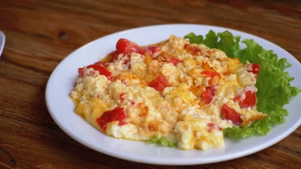 Plaat van de Georgische Omelet met tomaten, kaas en kruiden op een houten tafel in een Restaurant. — Stockvideo