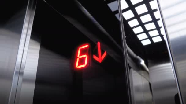 Cyfrowy wyświetlacz w windzie, która wywodzi się od podłogi ze strzałką w dół — Wideo stockowe