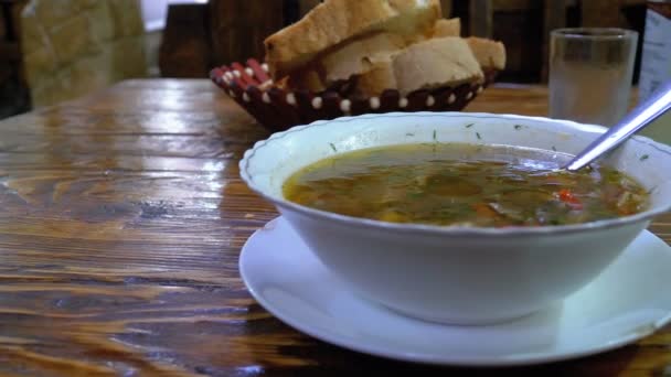 Sopa de champiñones georgianos en un plato sobre una mesa de madera en un restaurante — Vídeos de Stock