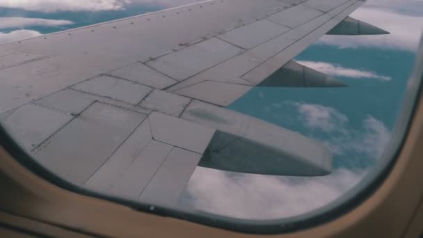 Uitzicht uit het raam van de vliegtuig passagier op de vleugel vliegen boven de wolken — Stockvideo