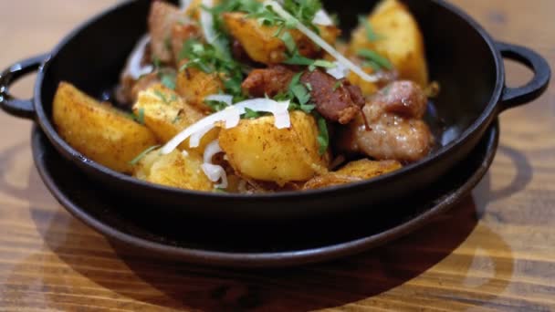 Озил, запеченный картофель с мясом на сковороде на деревянном столе в грузинском ресторане — стоковое видео